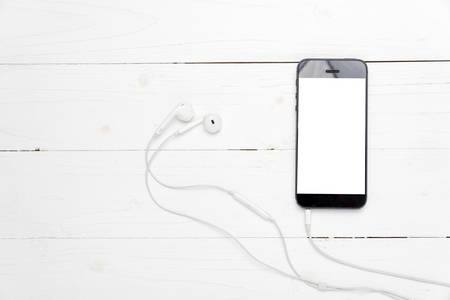 smart phone with earphone on white wood background