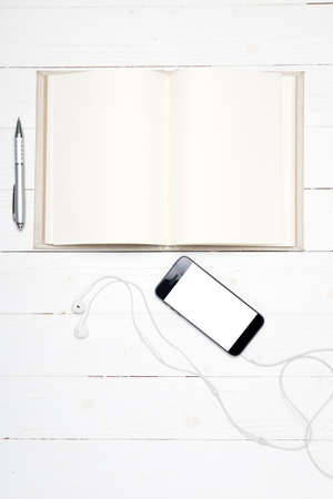 smart phone with open notebook on white wood backgroundの写真素材