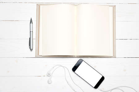 smart phone with open notebook on white wood backgroundの写真素材