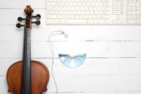 keyboard computer with dvd disc and violin on white wood backgroundの写真素材