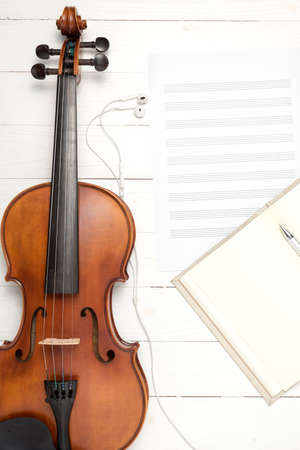 violin with music paper note and notebook on white wood backgroundの写真素材