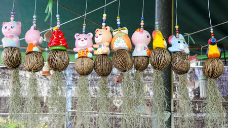 Many ceramic doll hanging containing spanish moss (Tillandsia usneoides) at flower shopの写真素材