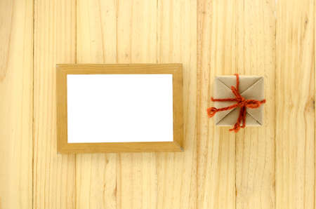 top view of craft gift box with photo frame on wood backgroundの写真素材