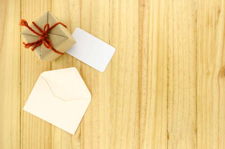 top view of craft gift box with envelope on wood background