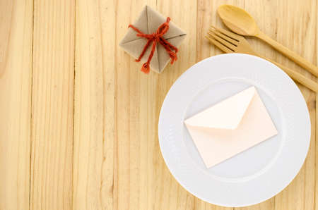 top view of craft gift box with envelope on wood background dish on wood background concept food for...