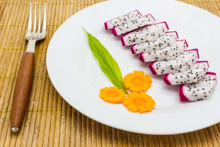 Sliced dragon fruit on the plate isolated on white backgroundの写真素材
