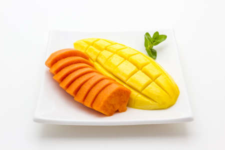 Mango and Papaya on white plate isolated on white backgroundの写真素材