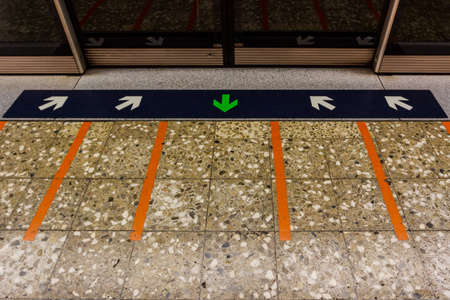 MRT station platform edge. Painted waiting line on the floor.