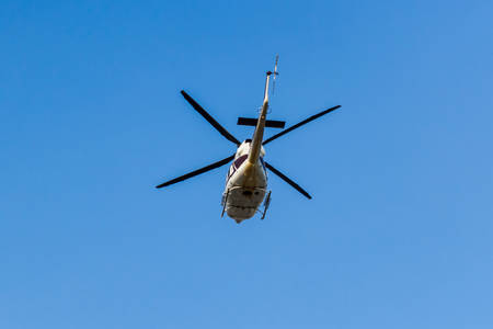 Helicopter flying isolated on the blue sky background. 