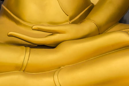Close up golden hand of buddha statue in thai temple.の写真素材