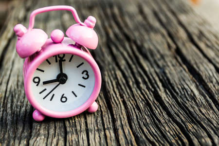 Close up small pink watch on wooden table の写真素材
