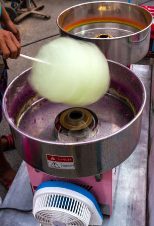Yellow spun sugar in a Cotton Candy Machine の写真素材