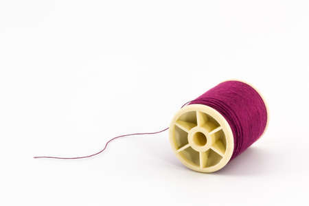 Red thread spools of sewing thread isolated on white background.