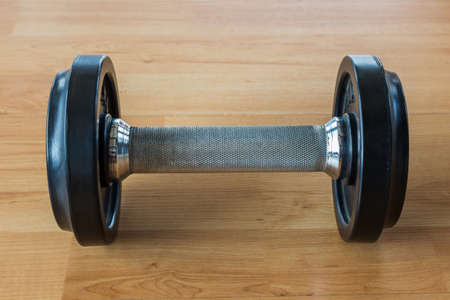 Many black dumbbell lined up in a fitness room.