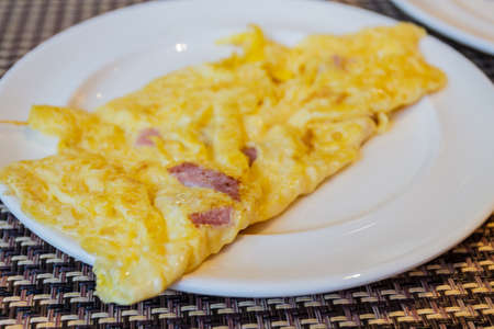 Closeup omelet with ham on white plate.の写真素材