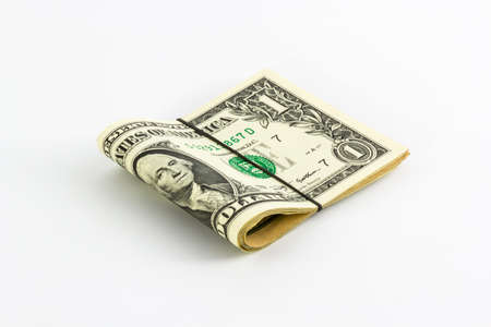 One dollar banknotes rolled up with rubberband isolate white.
