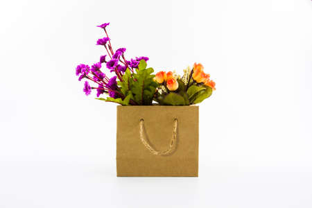 Artificial colorful of flowers made from cloth in shopping bag isolated white background.の写真素材