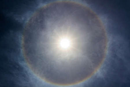 Sun halo with circular rainbow, due to ice crystals in atmosphere.