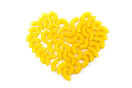 Raw macaroni heart shaped on white background. の写真素材