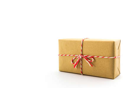 Cardboard carton wrapped with brown paper, tied with string on white background. 