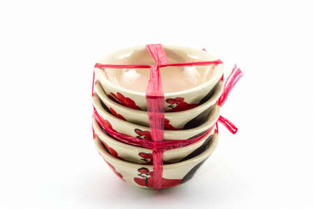 Stack of empty bowl overturn for sale tied with string on white background. の写真素材