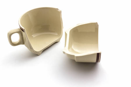 Broken coffee cups on white background.