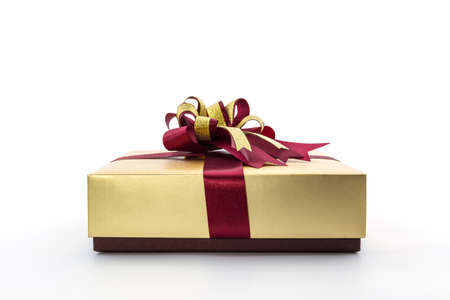 Gold and brown gift box with ribbon bow on white background. 