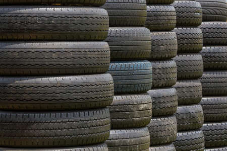 Stack of old wheel black tyres texture background. の写真素材