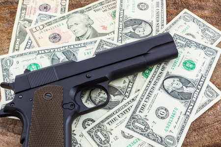 Close up money with Gun on wood background.の写真素材