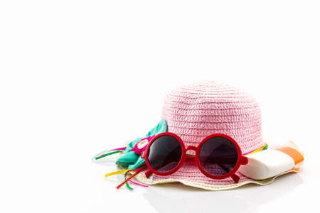 Pink woven hat with body lotion and red sunglasses on white background.の写真素材