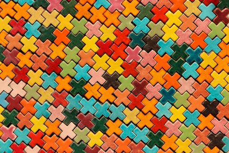 Multicolored tile shape of a cross on the wall, background.の写真素材