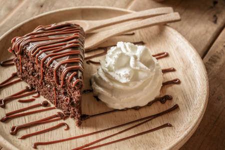 Chocolate cake with chocolate creame on wood plate.の写真素材