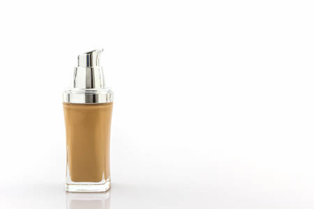 Beige make up foundation in luxurious bottle on white background.