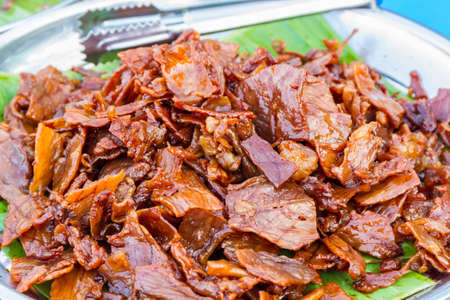 Slice of Baked carameled pork belly on green leaf.の写真素材