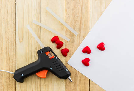 Closeup electric hot glue gun apply the glue to making postcard with red heart.の写真素材