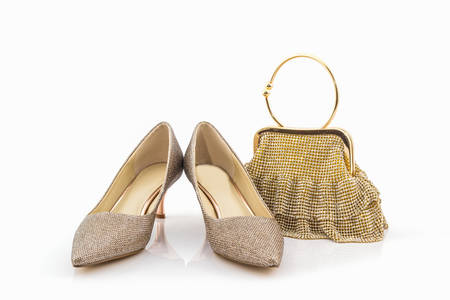 Collection of golden shoes and bag on white background.の写真素材