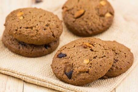 Chocolate chip cookies on wooden background.