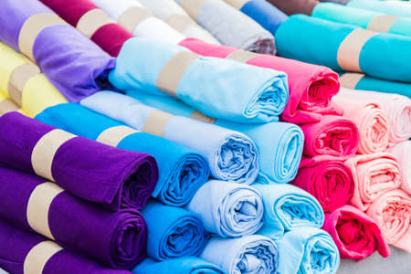 Row of variety multicolored shirt clothes hanging on shelf outdoor for sale, no brandnames or...