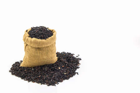 Rice berry in small burlap sack on white background.の写真素材