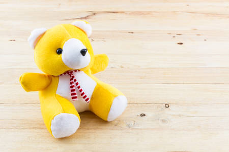 Yellow teddy bear toy on wood background.の写真素材