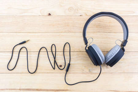 Black Headphones on wood desk Background.の写真素材