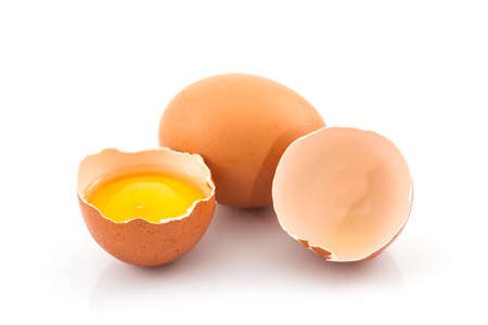 Cracked egg and shell on a white background. Broken chicken egg.の写真素材
