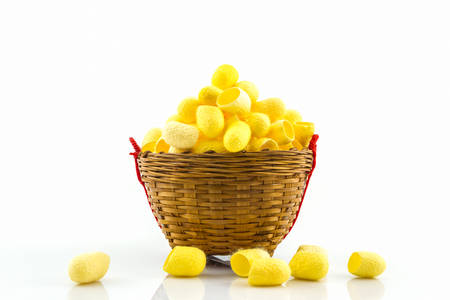 Close up silkworm cocoon in basket on wood background.の写真素材
