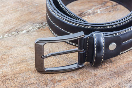 Black leather belt for men on wood background.の写真素材