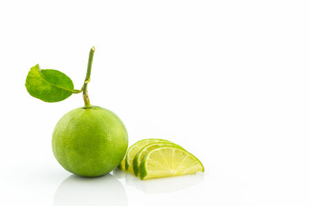 Limes whole and slices on white background.の写真素材
