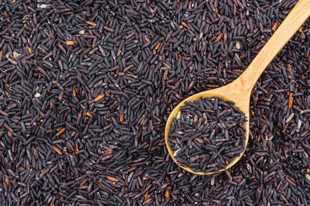 Rice berry in a wooden spoon ,texture background.の写真素材