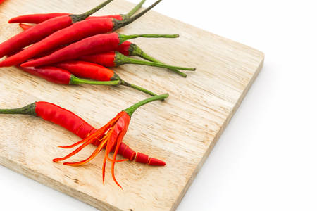 Red chili or chili pepper on wooden cutting board.