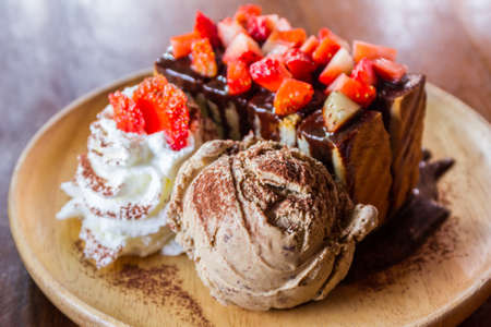Honey toast with fresh strawberry. Chocolate ice cream and toasted bread with strawberries.の写真素材