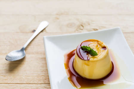 Pudding Caramel Custard in white plate on wooden background.の写真素材