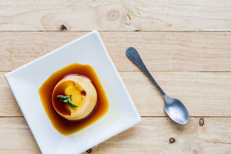 Pudding Caramel Custard in white plate on wooden background.の写真素材